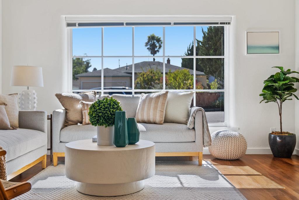 a living room with furniture potted plant and a large window