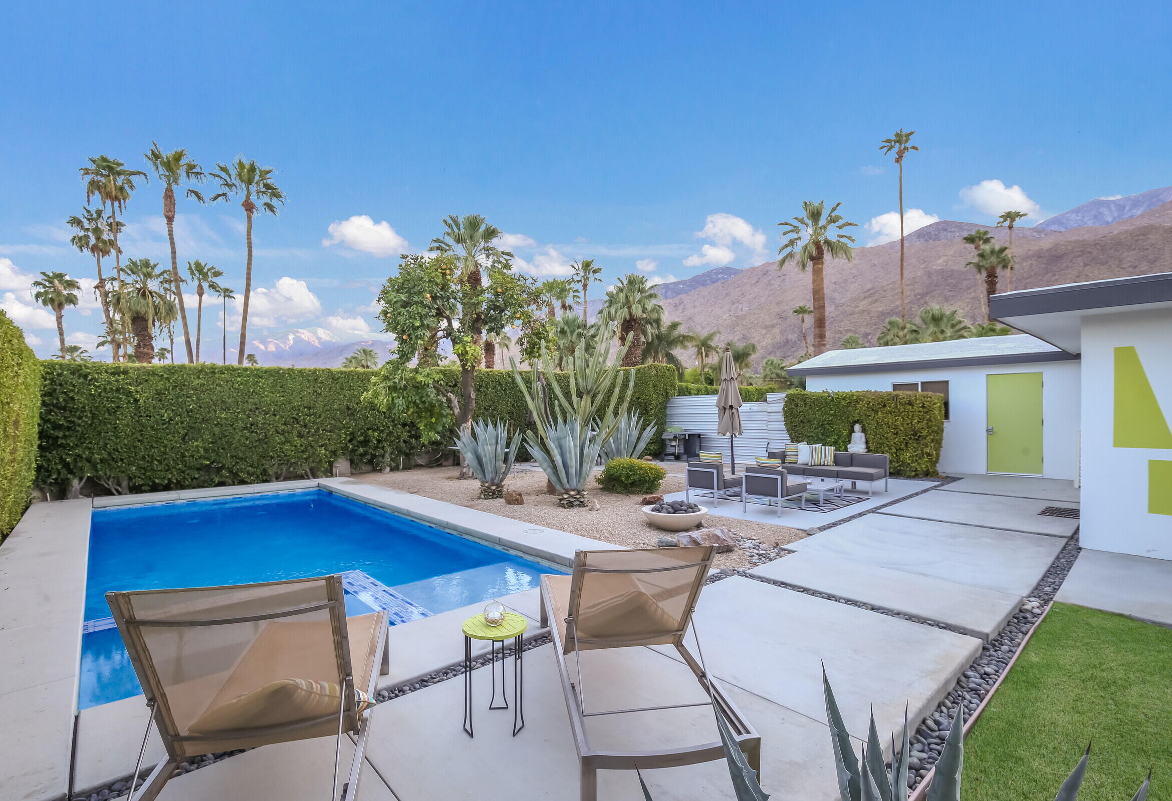 a view of a chairs and table in the patio and a swimming pool