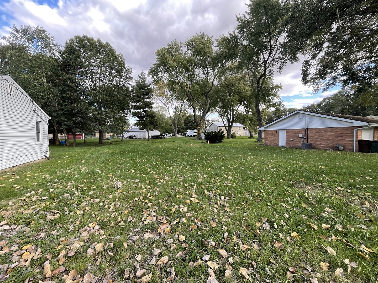 a view of a house with a big yard and large trees