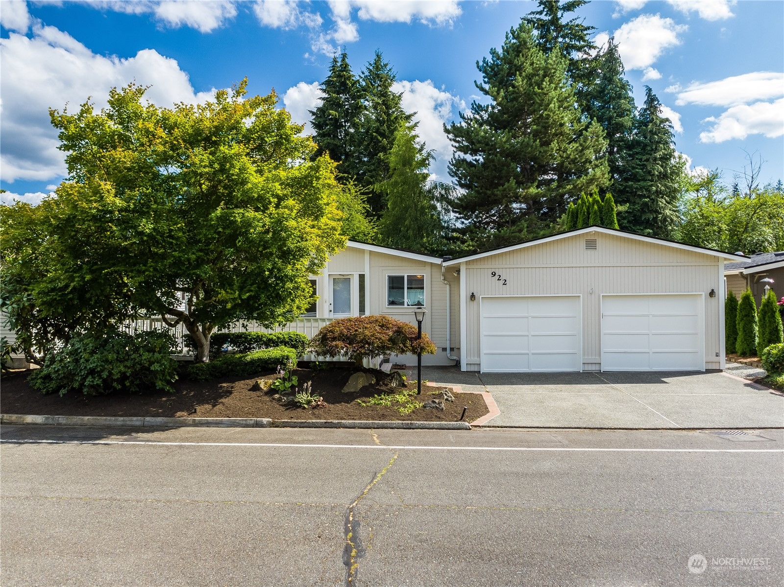 a front view of house with yard and trees in the background