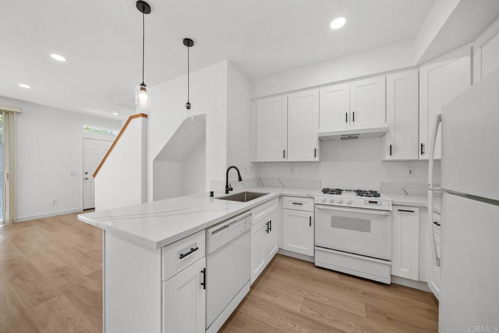 a kitchen with white cabinets appliances and sink