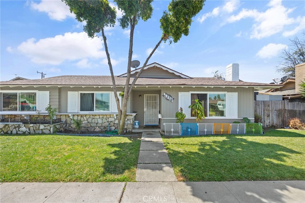 a front view of a house with a garden and yard