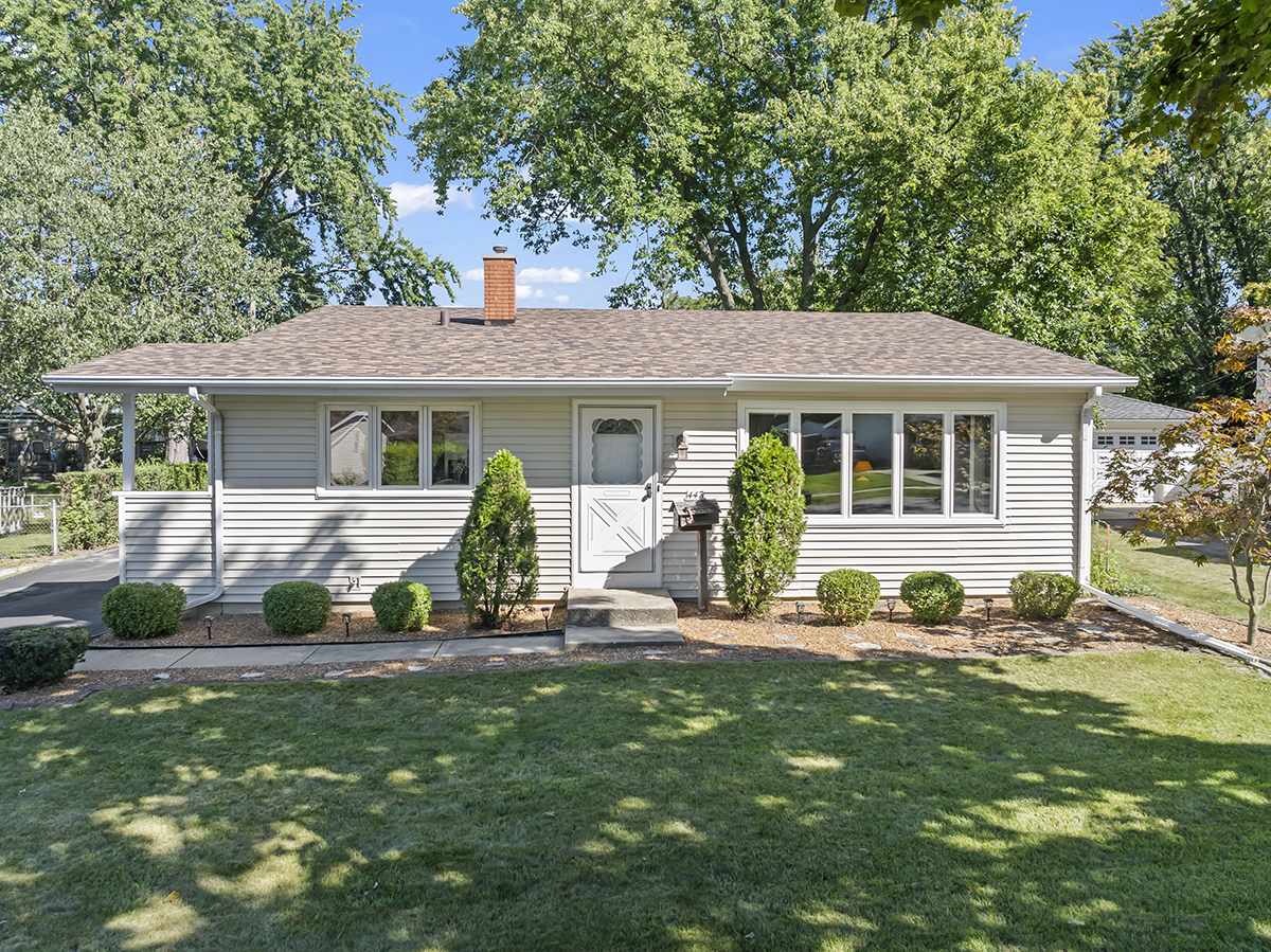 a front view of a house with a yard and green space