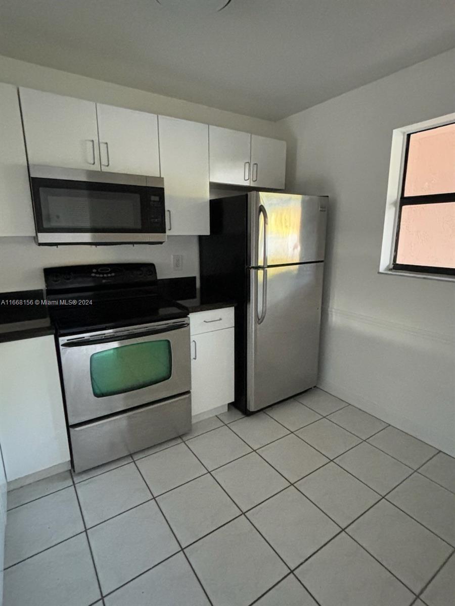 a kitchen with stainless steel appliances a refrigerator sink and microwave