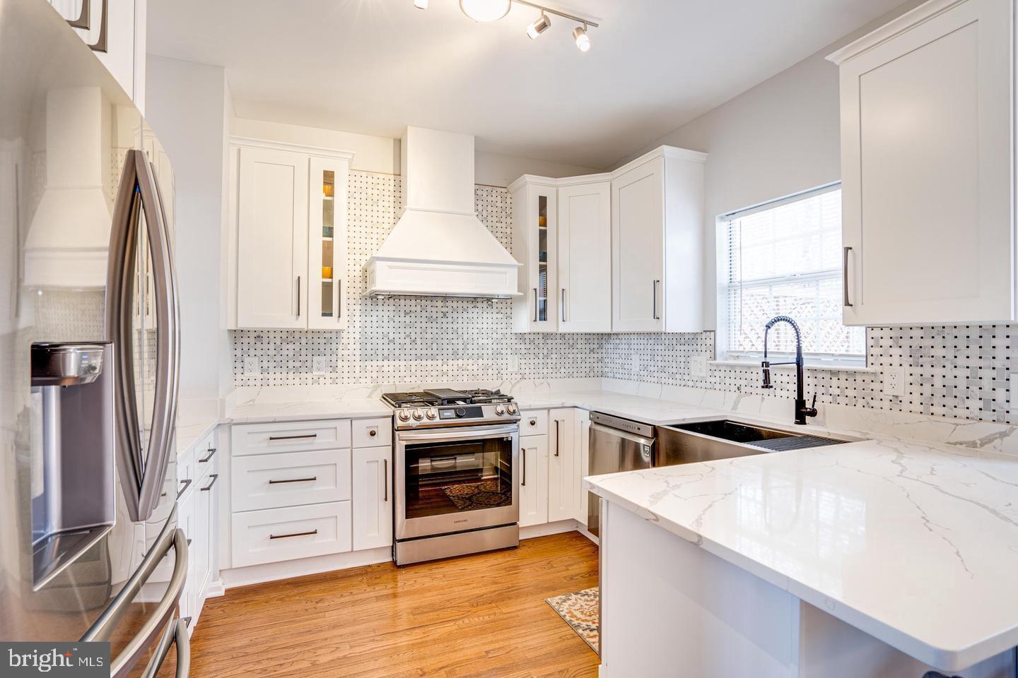 a kitchen with stainless steel appliances a sink stove and refrigerator