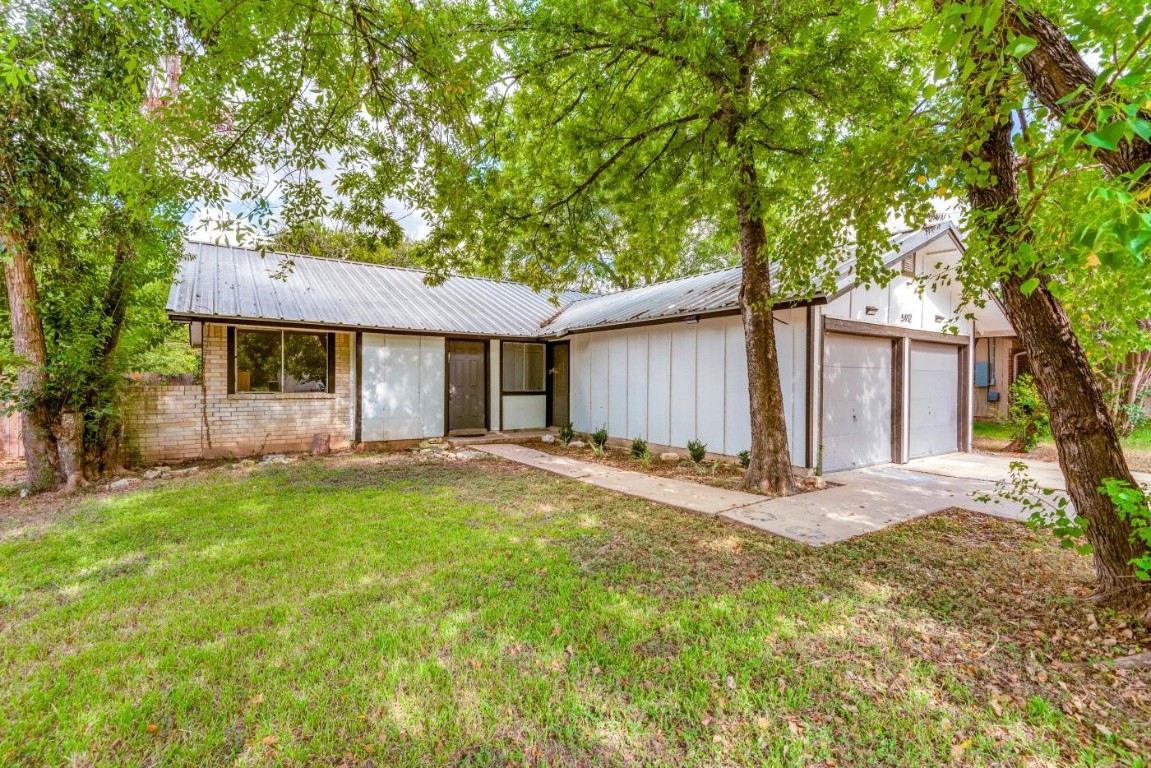 a view of a house with backyard and tree