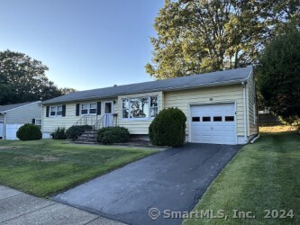 a view of a house with a yard and potted plants