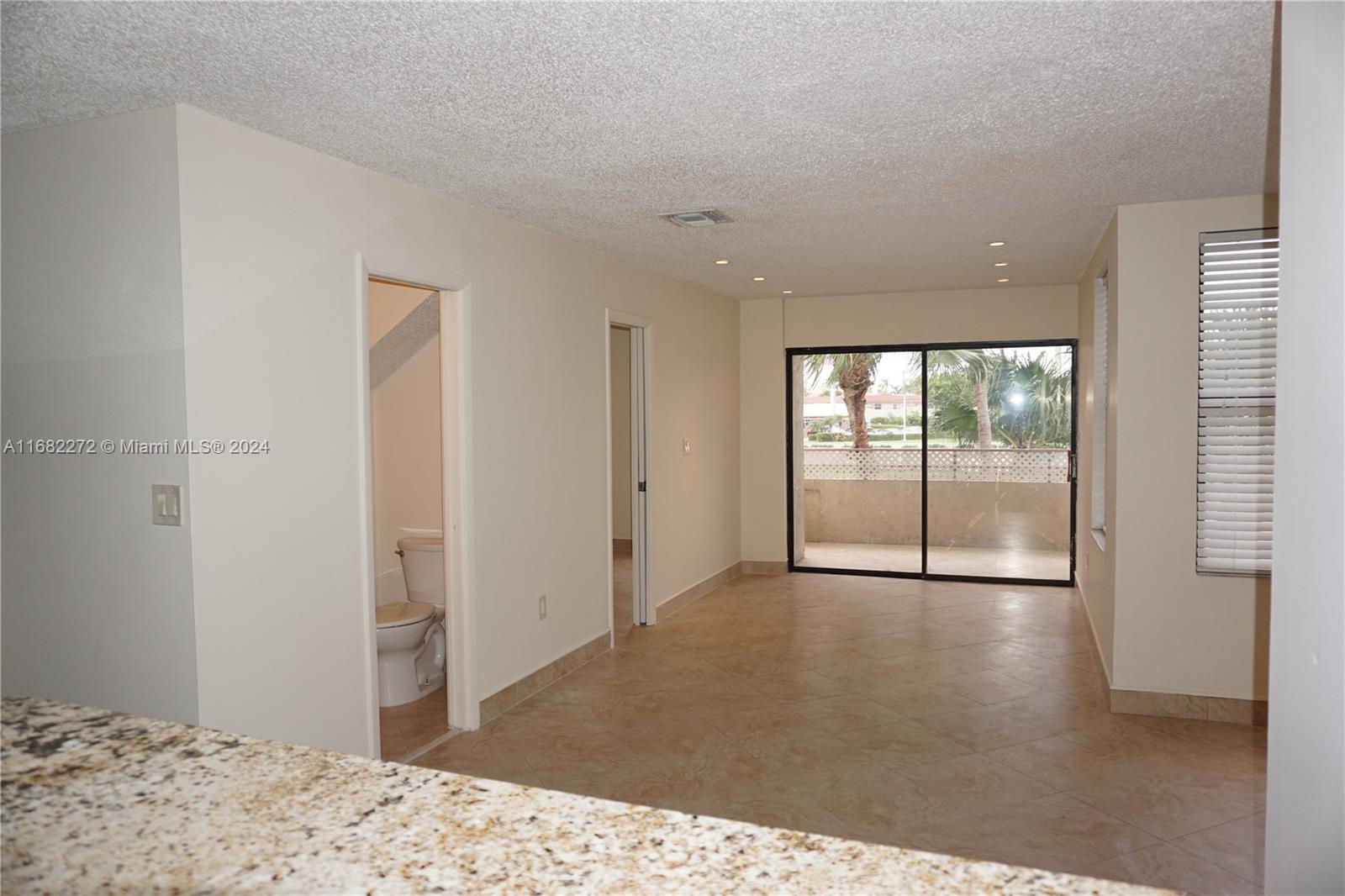 a view of a big room with wooden floor and a window