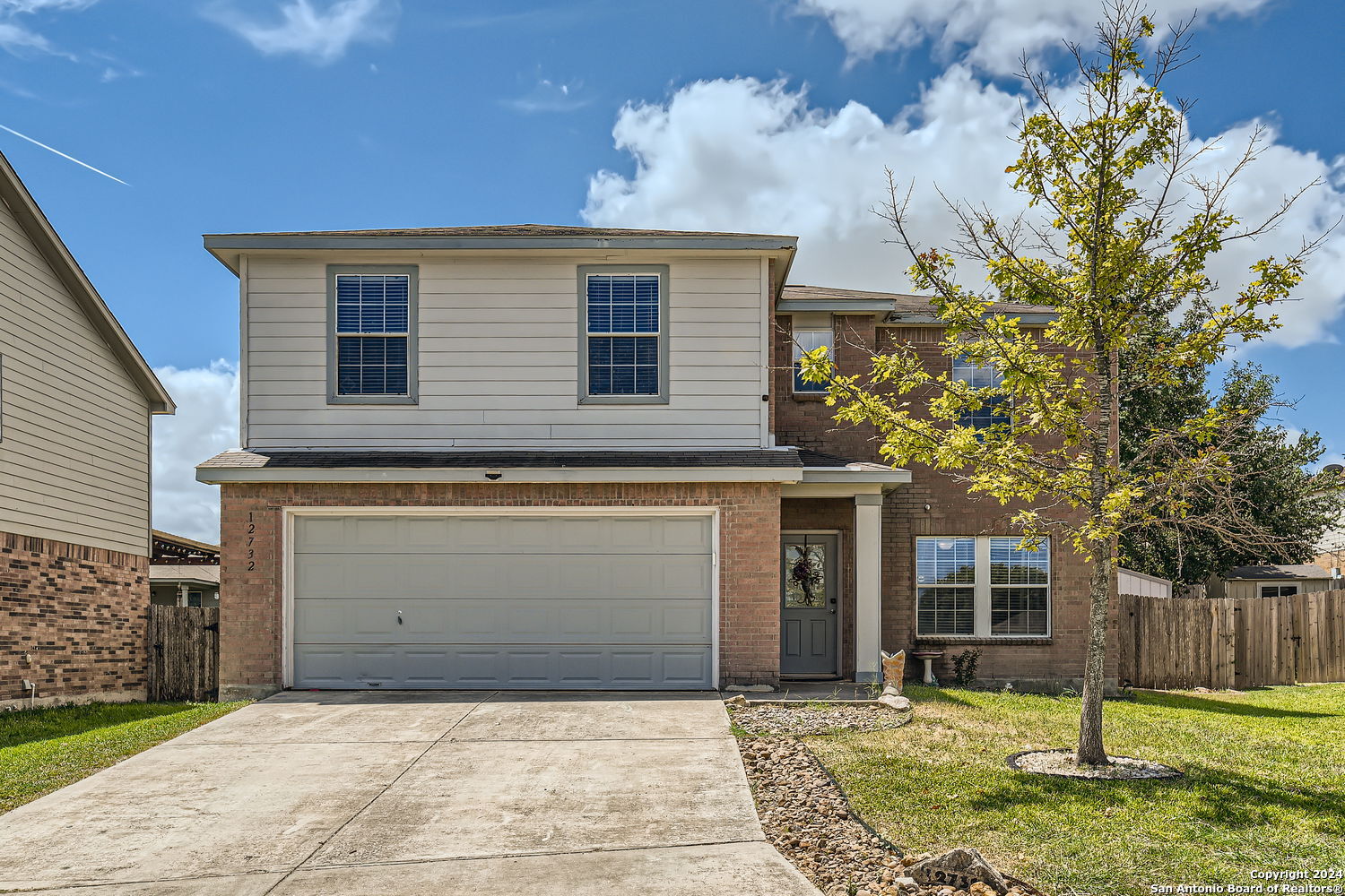 a front view of a house with a yard and garage