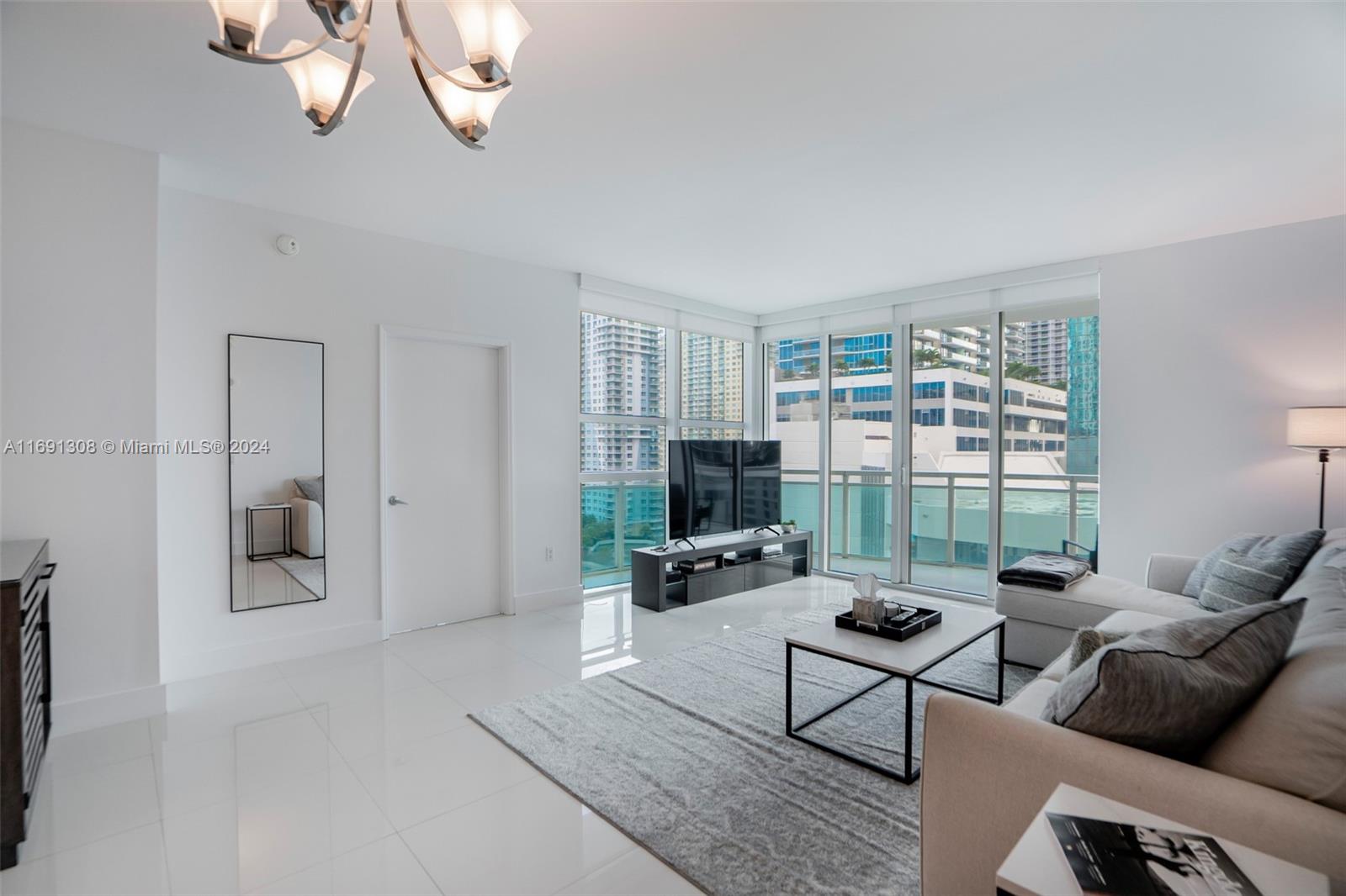 a living room with furniture a window and a chandelier