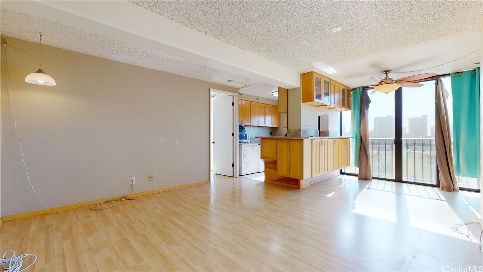 a view of a kitchen with wooden floor and a window