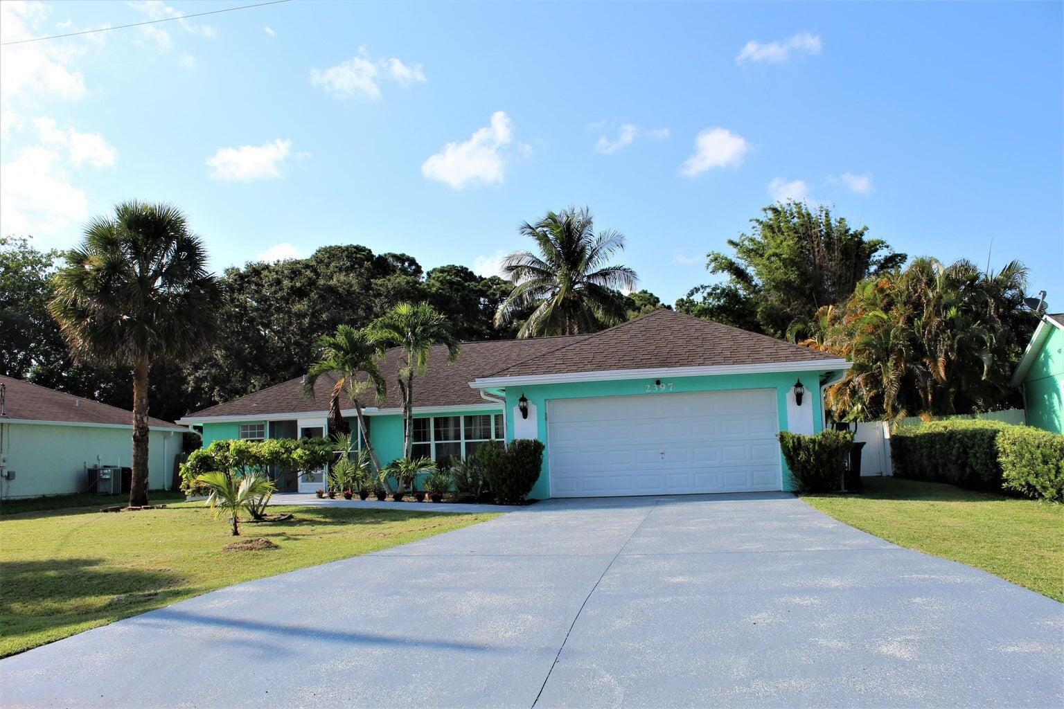 a front view of a house with a yard and trees