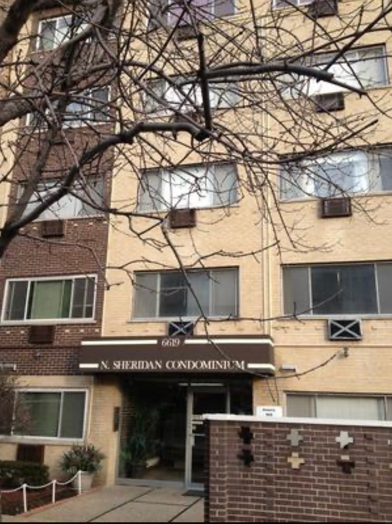 a front view of a building with large tree