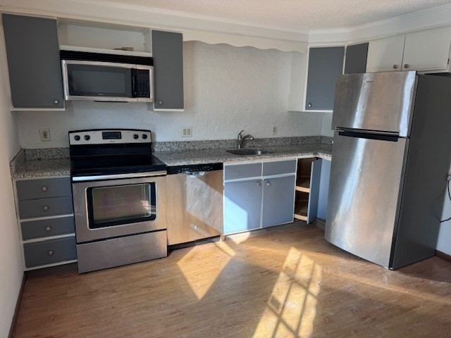 a kitchen with granite countertop a stove microwave and refrigerator