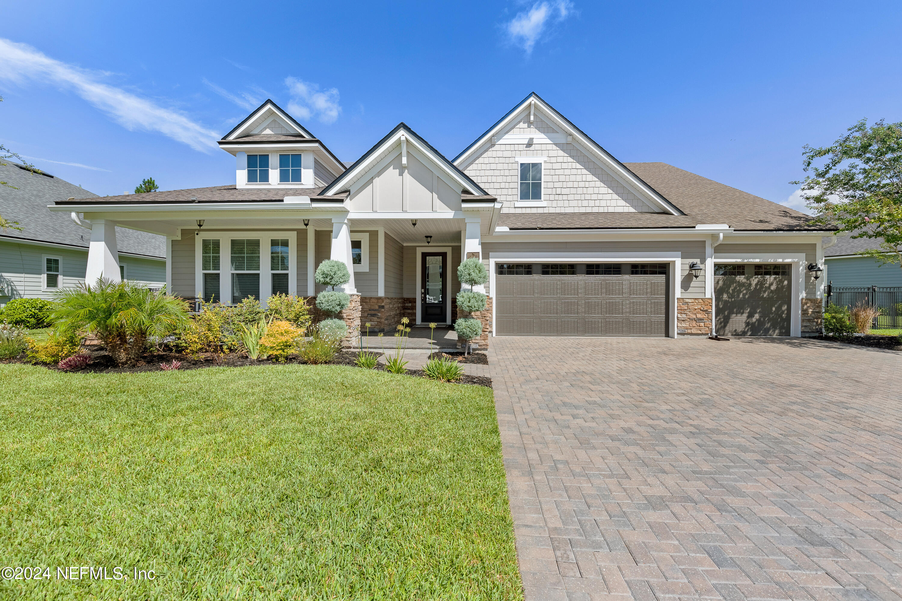 a front view of a house with yard and green space