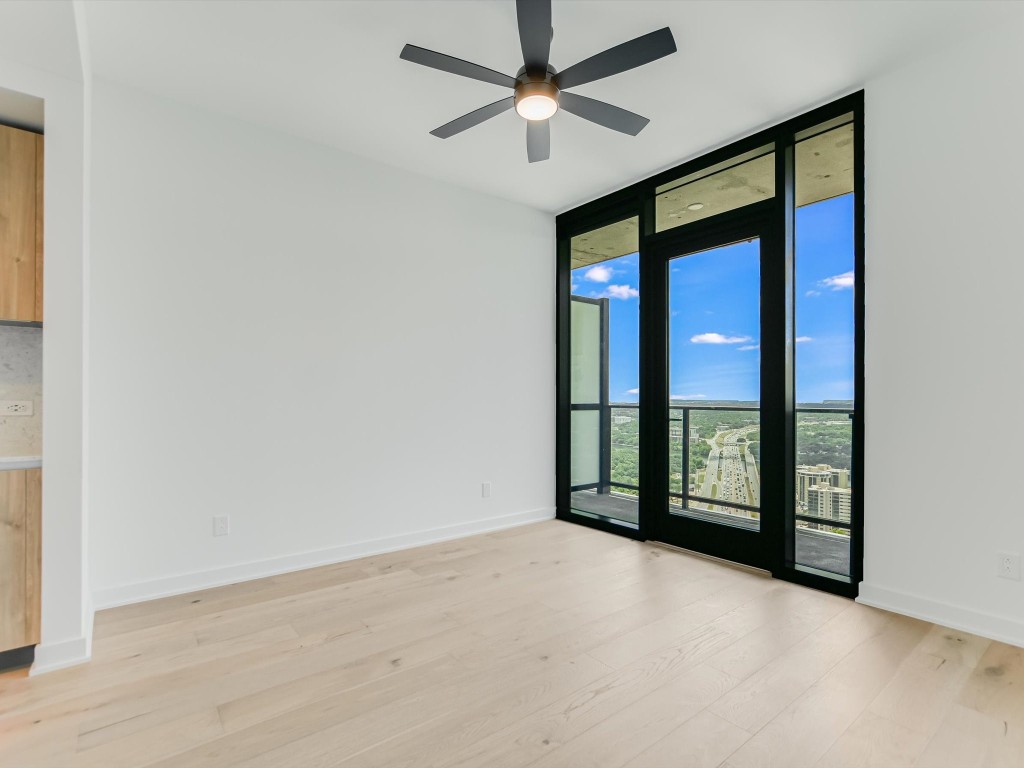 an empty room with windows and fan