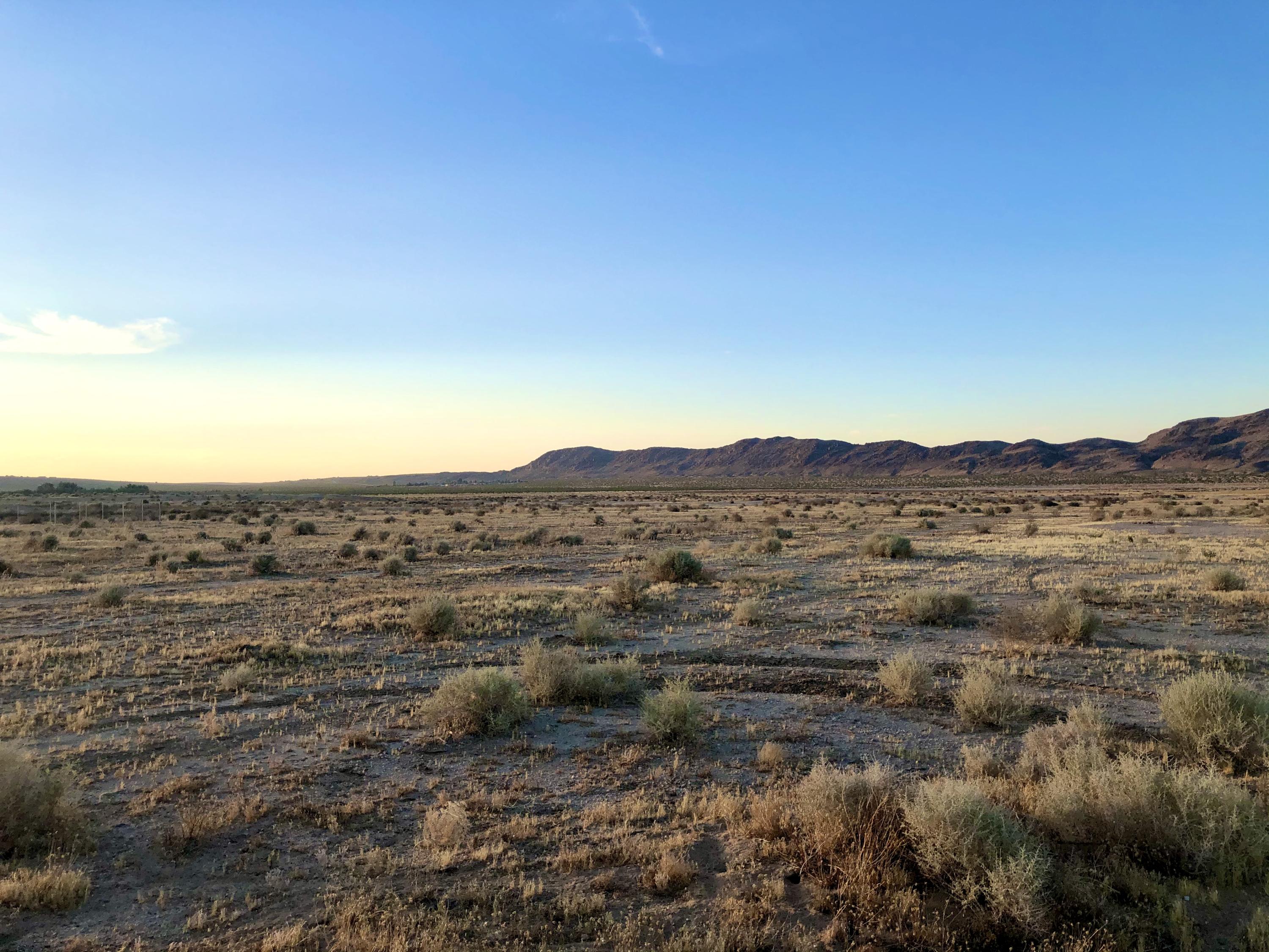 a view of a large mountain with mountains in the background