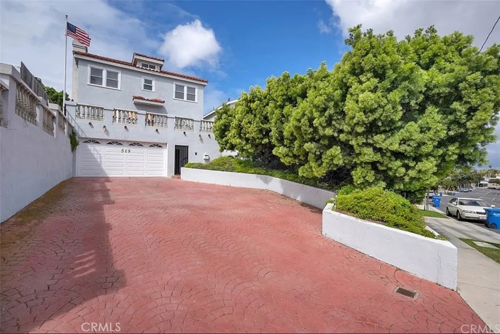 a view of a house with a yard and potted plants