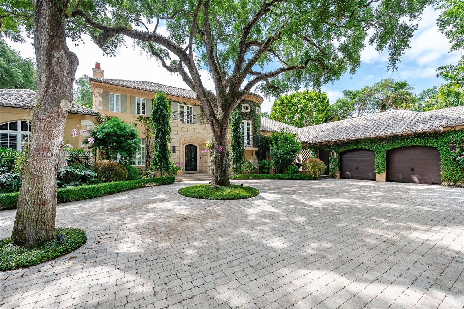 a front view of a house with a yard and potted plants