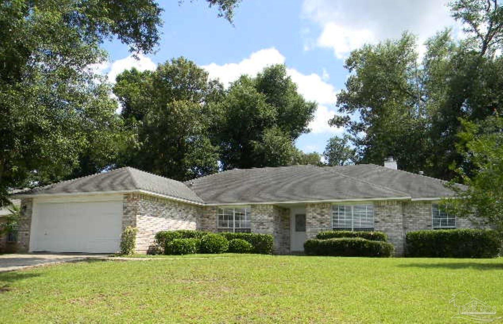 a view of a big house with a big yard and large trees