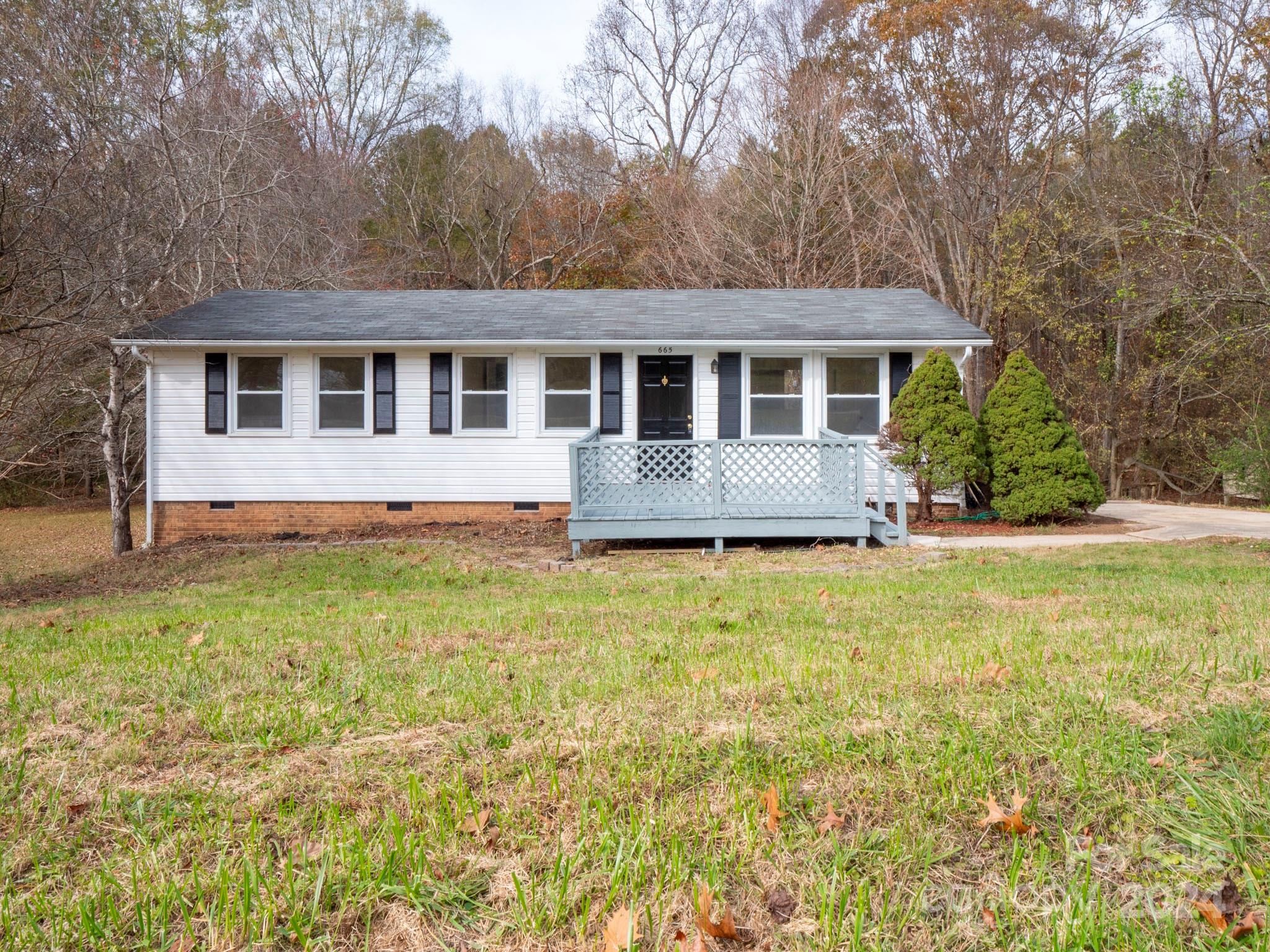 a front view of house with yard and trees around