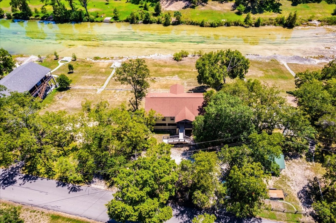 an aerial view of ocean with residential house lake and trees all around