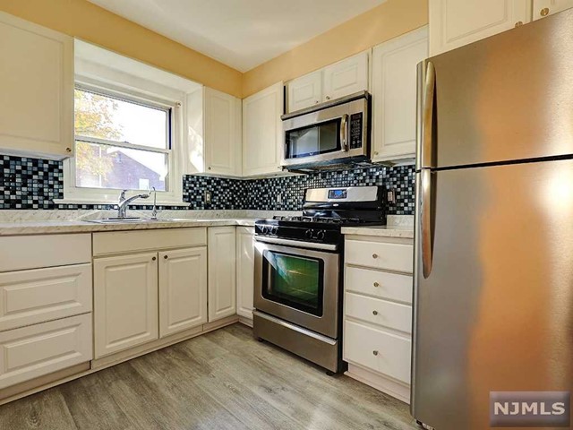 a kitchen with white cabinets and appliances