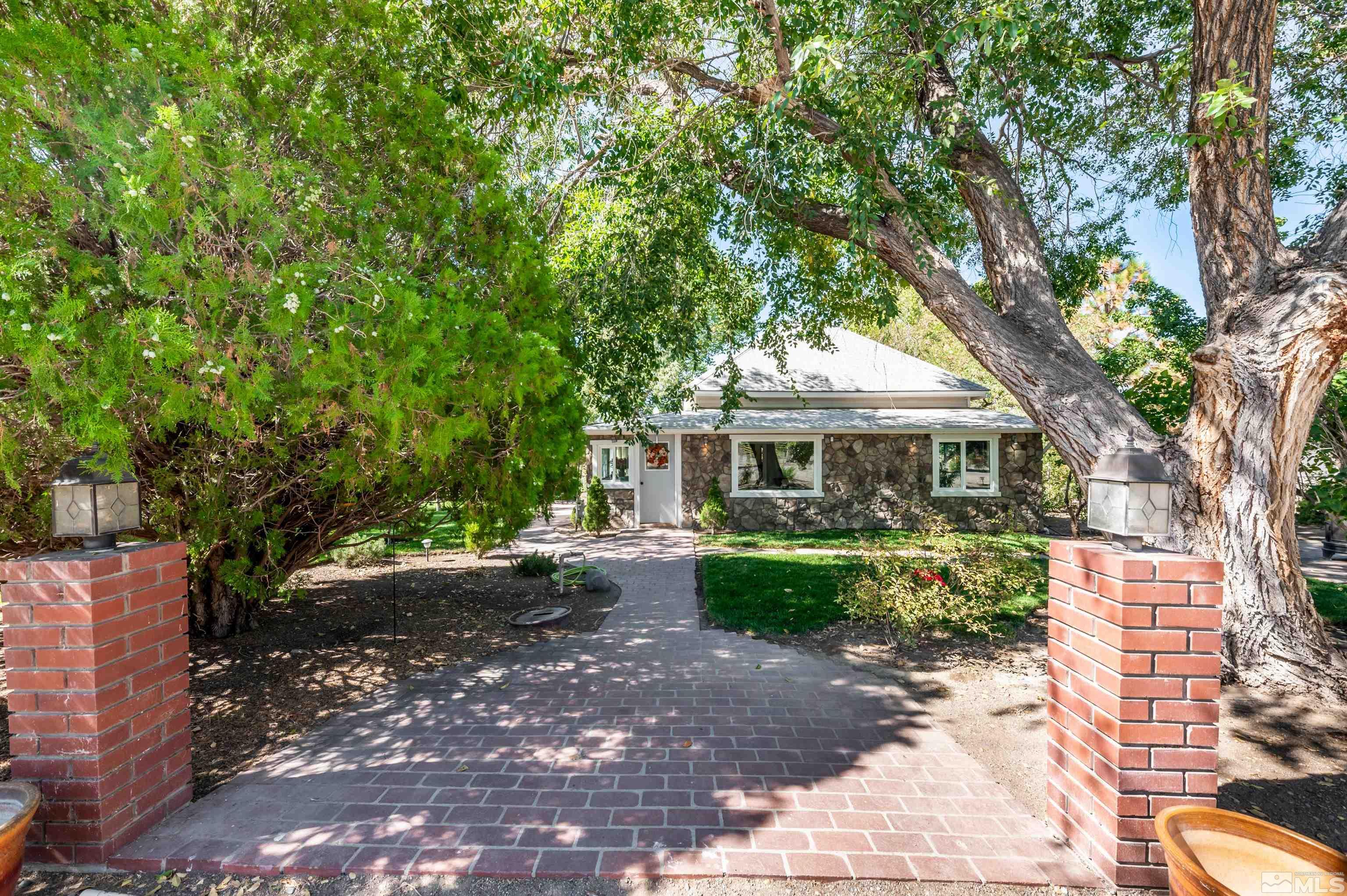 a front view of a house with yard garden and tree