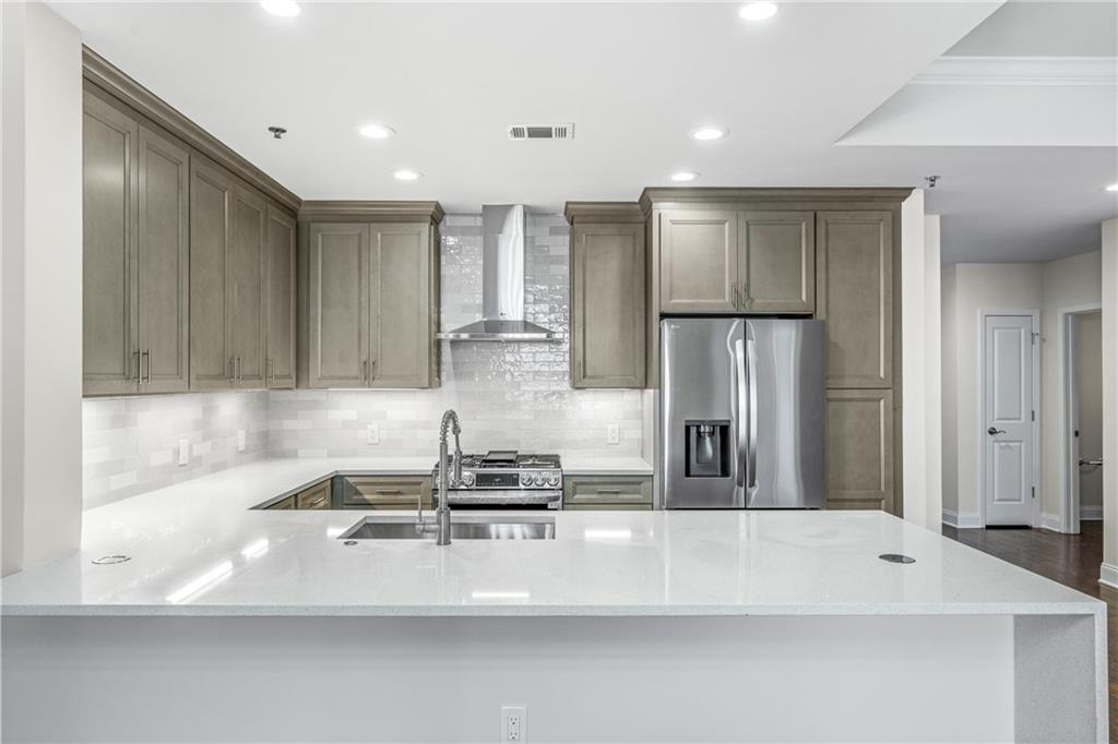 a kitchen with kitchen island a sink stainless steel appliances and cabinets