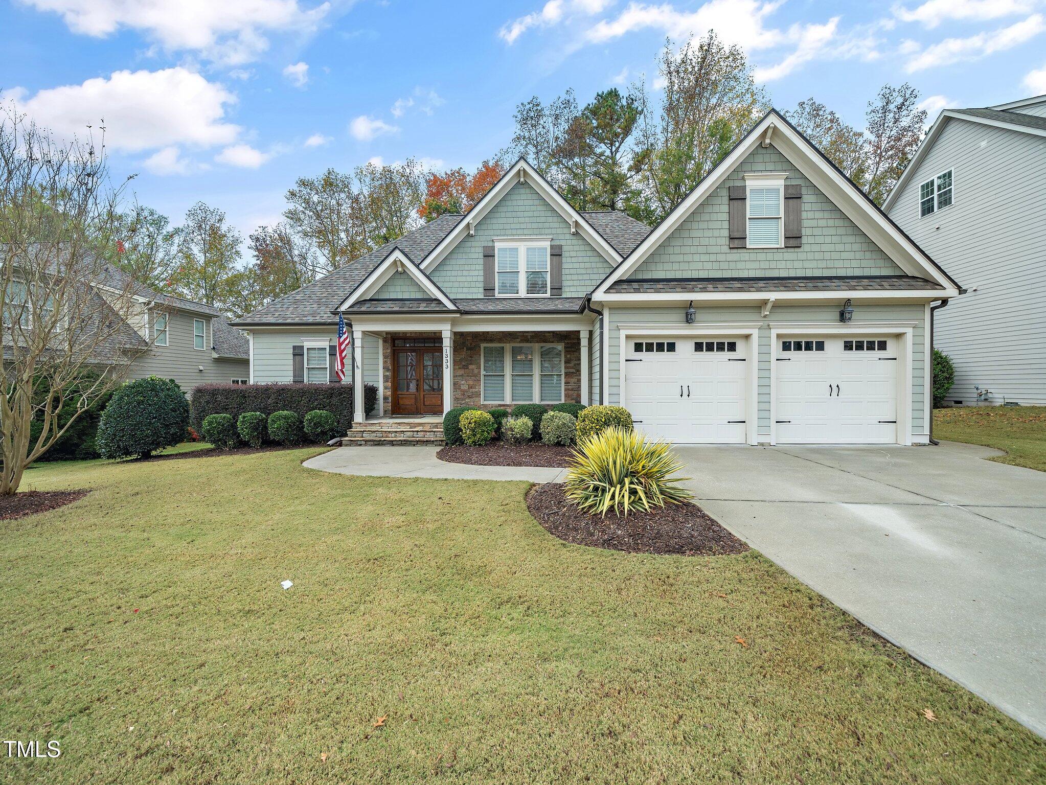 a front view of a house with a garden and yard