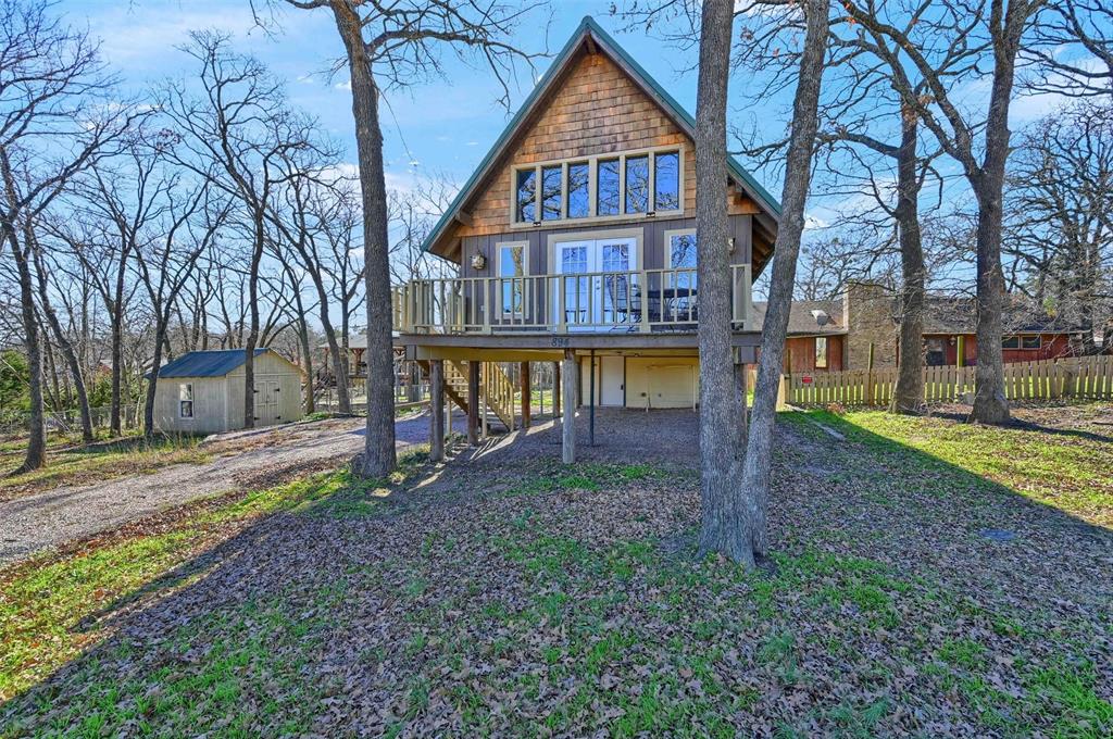 a view of an house with backyard and trees