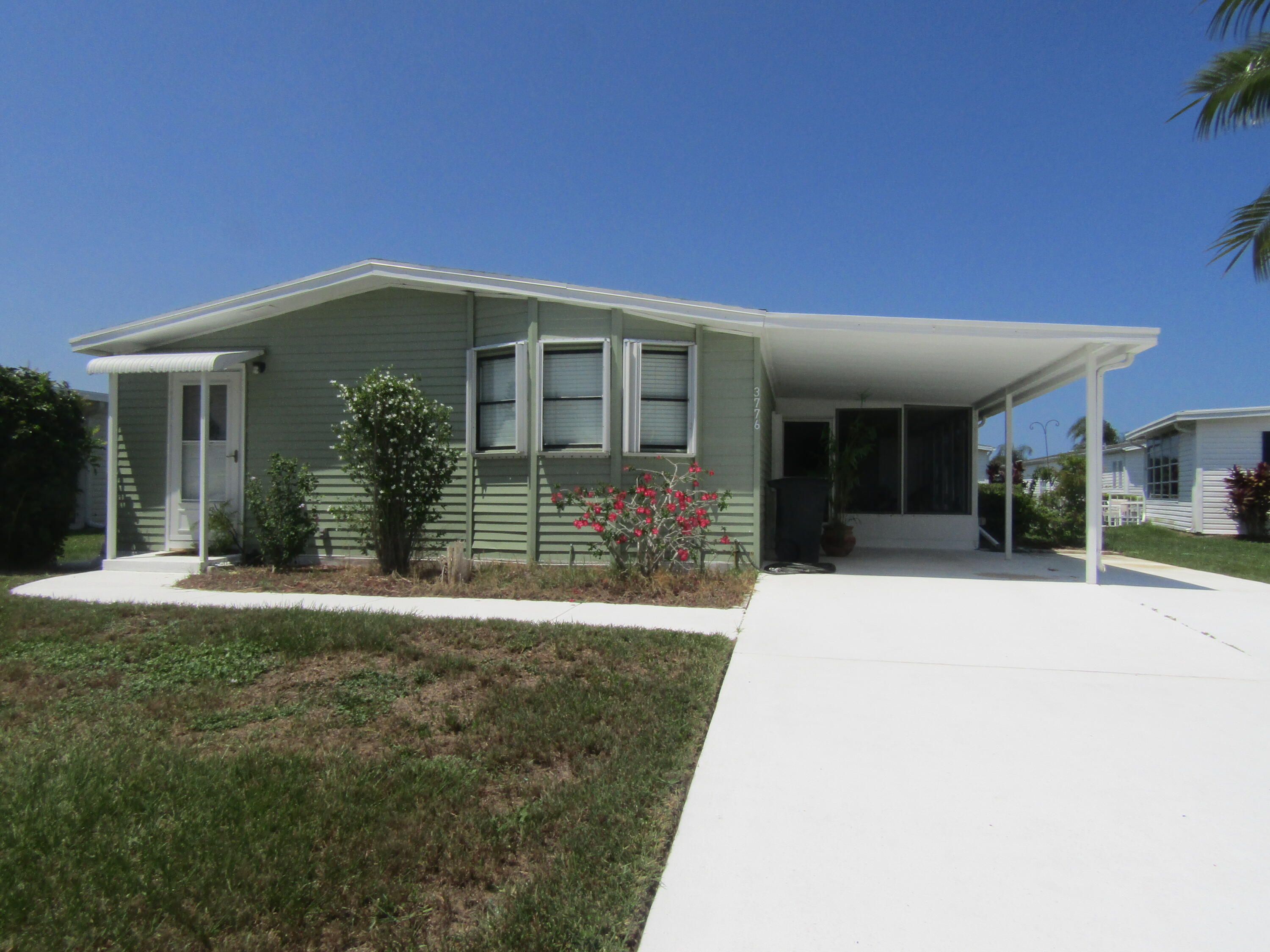 a view of a house with floor to ceiling windows and a yard