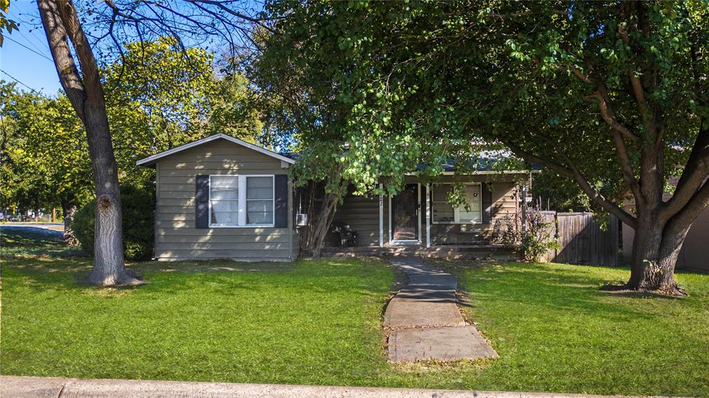 a front view of a house with a yard and trees