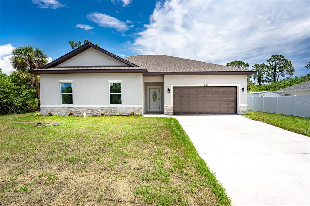 a front view of a house with a yard and garage