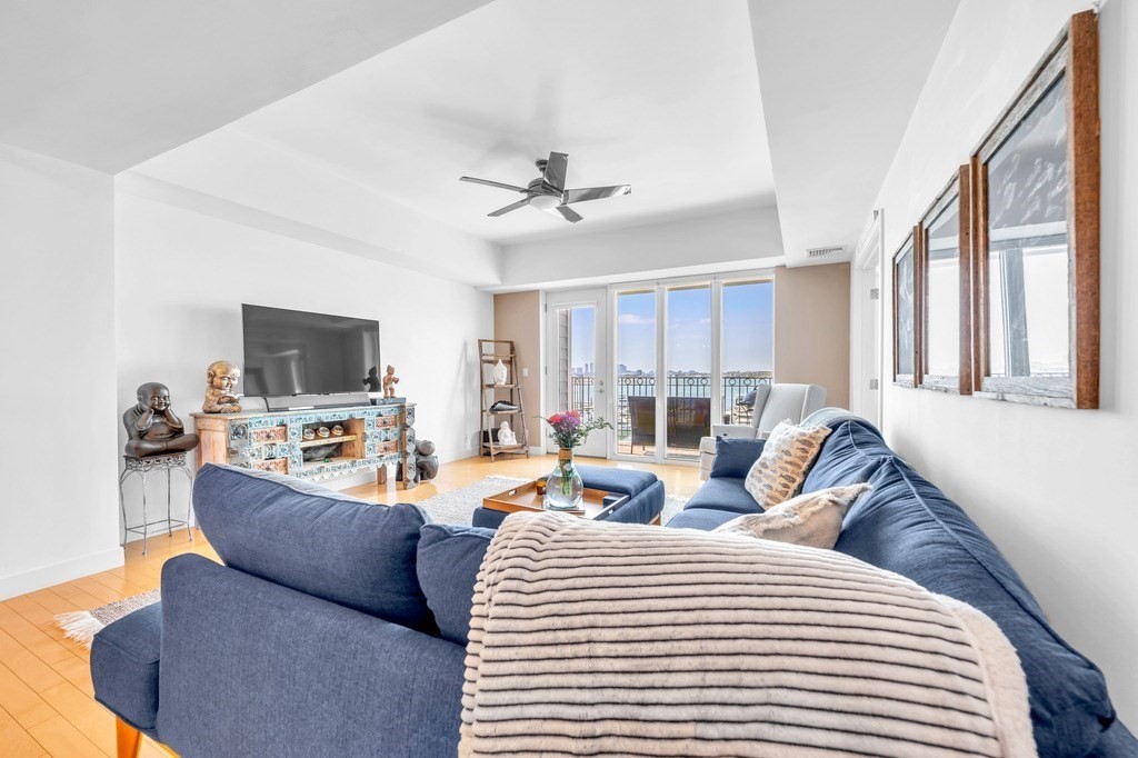 a living room with furniture a flat screen tv and a window