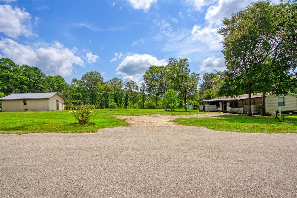 a view of a house with a big yard and large trees