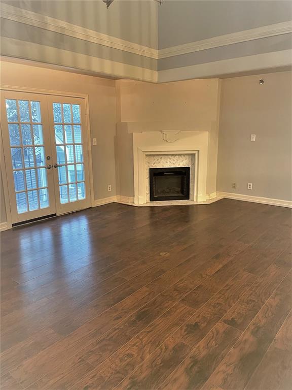 a view of an empty room with wooden floor and a fireplace