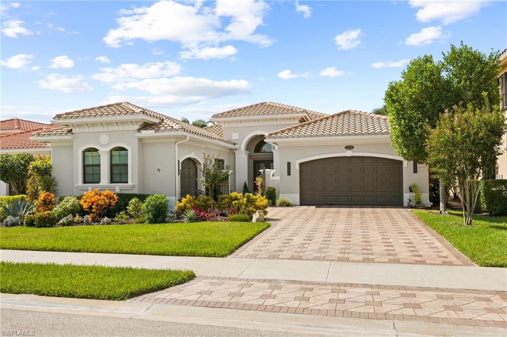 Mediterranean / spanish home with a garage and a front lawn