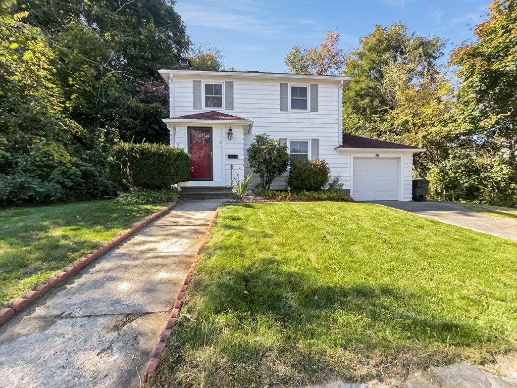 a view of a house with a yard and a tree