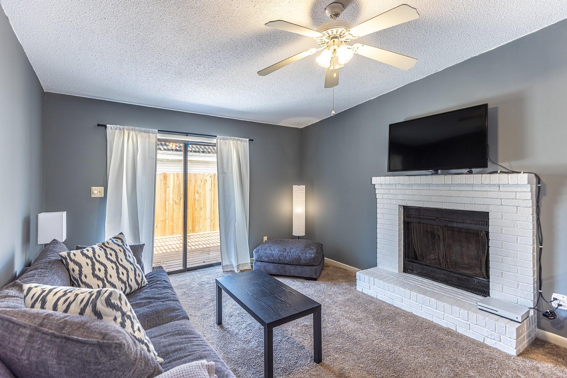 a living room with furniture a flat screen tv and a fireplace