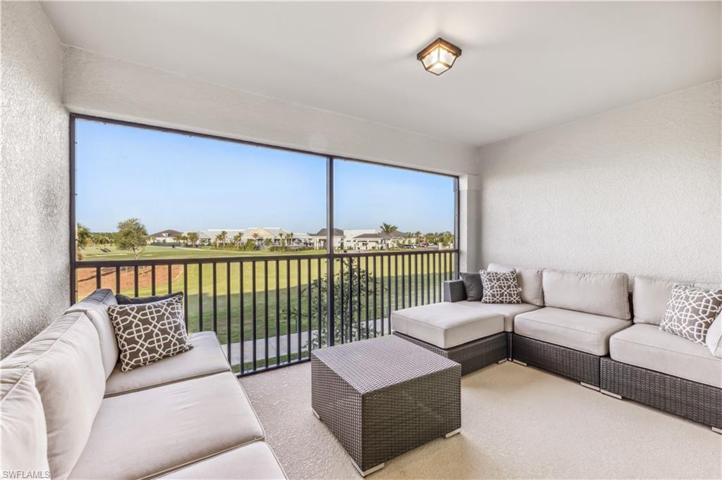 a living room with furniture and a floor to ceiling window