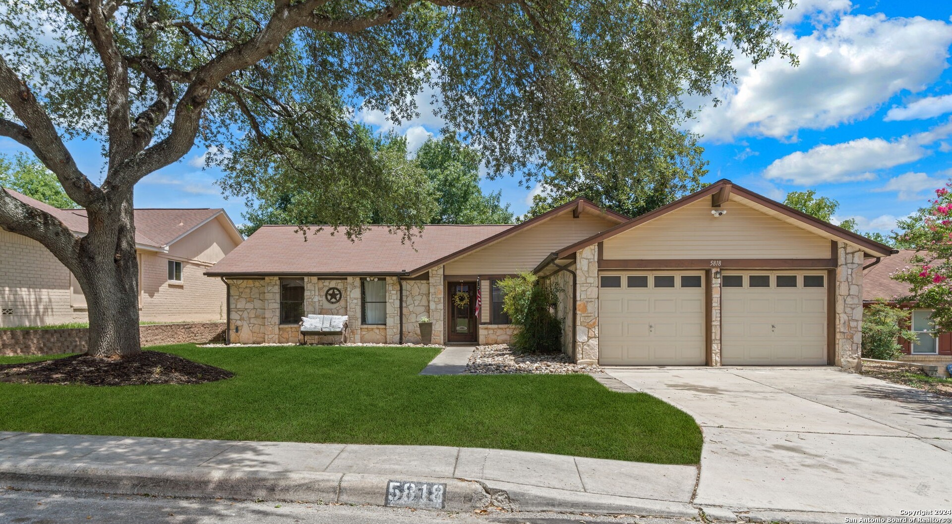 a view of a house with a yard and large tree