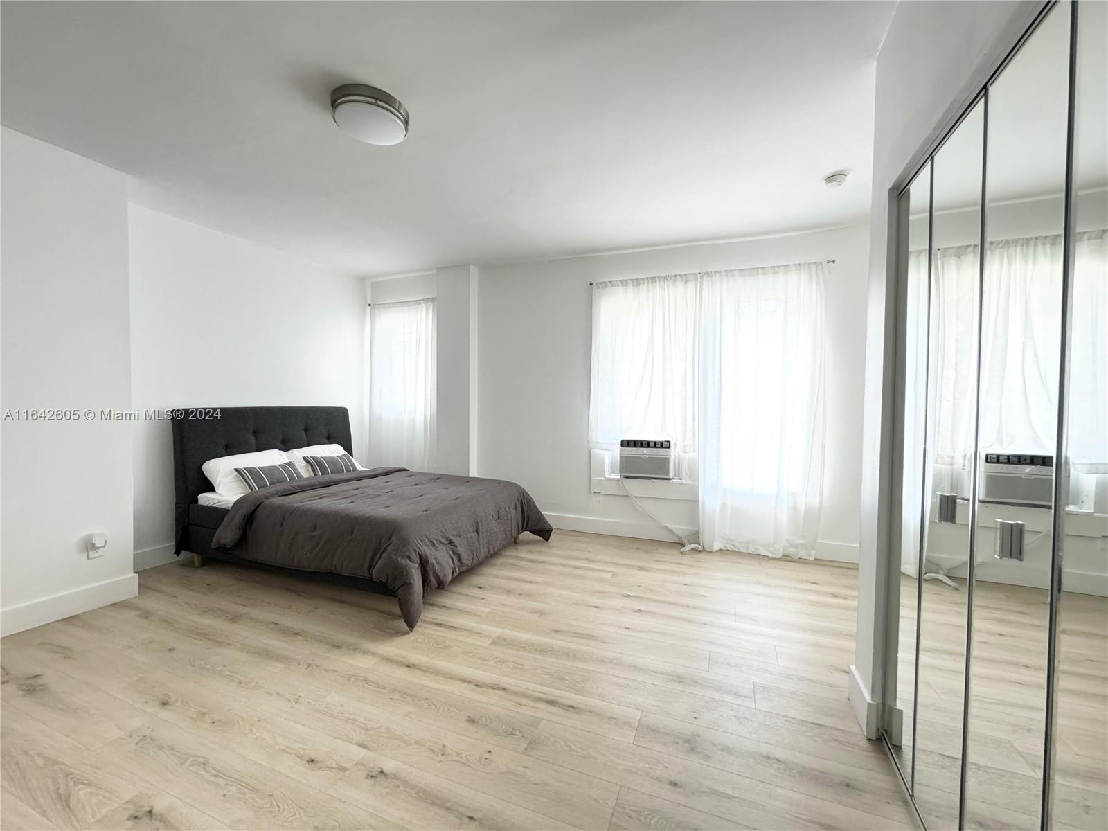 a bedroom with a large bed and a chandelier