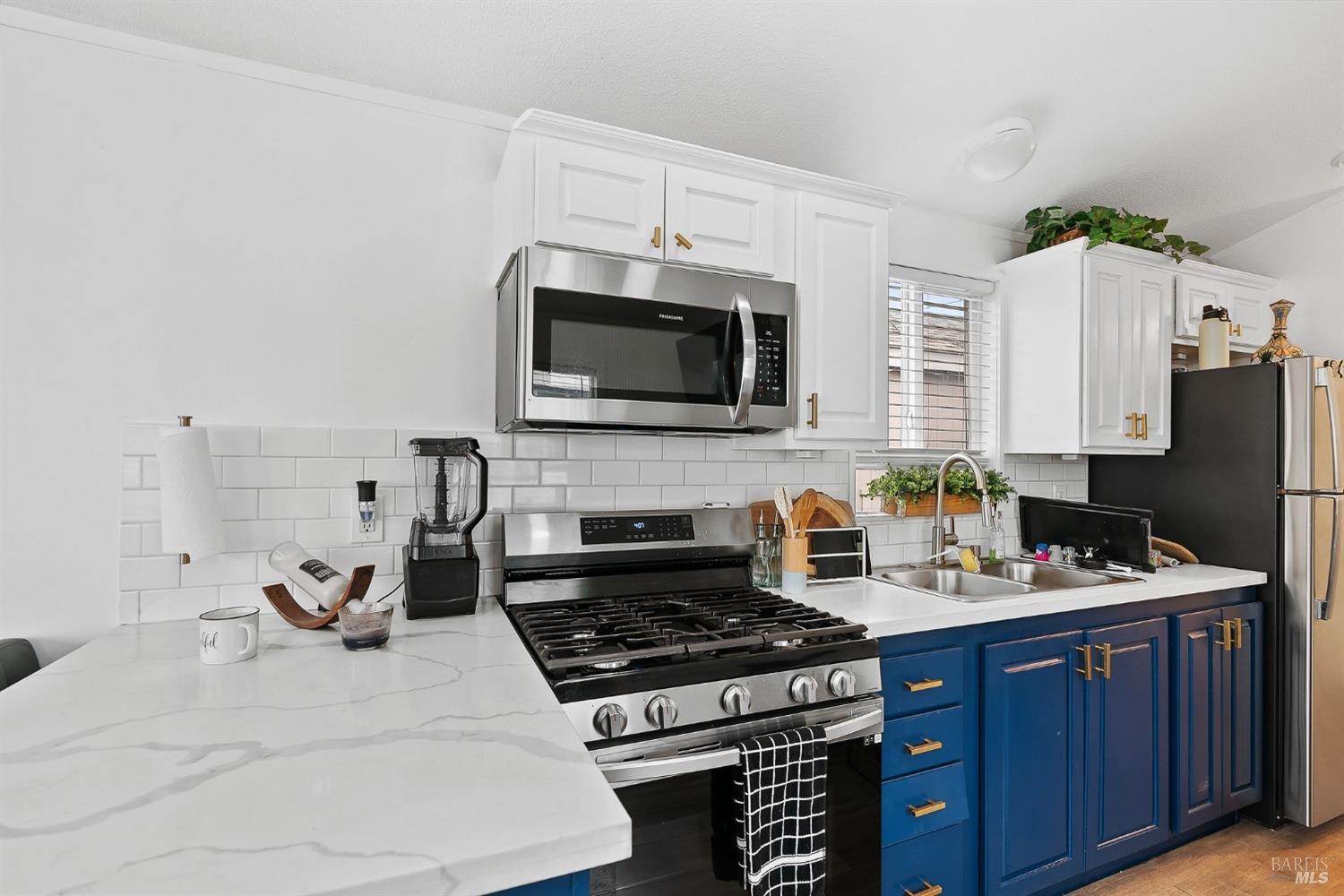 a kitchen with stainless steel appliances a stove a sink a microwave and wooden cabinets