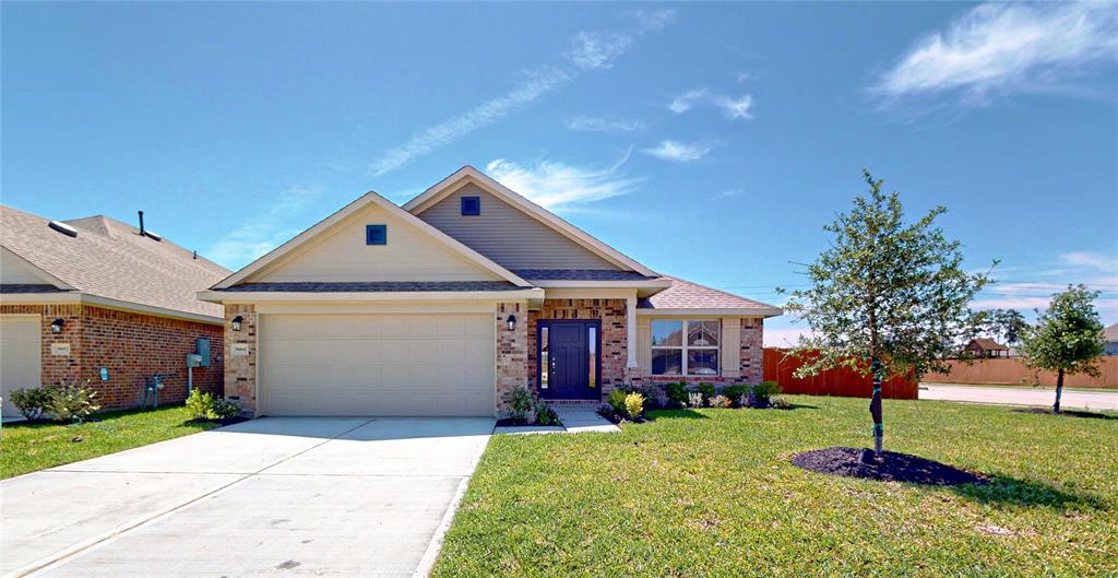 a front view of a house with a yard and tree