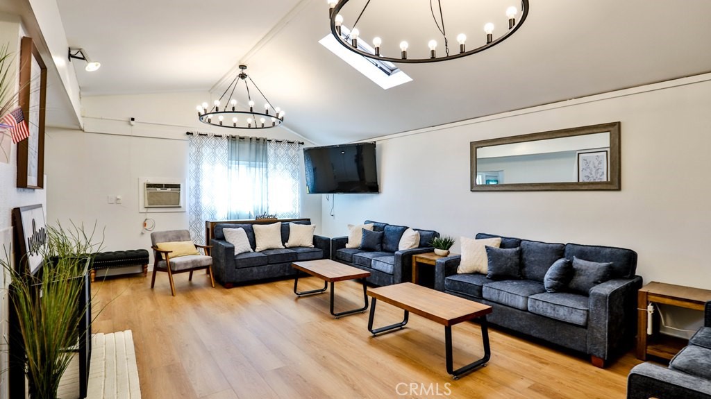 a living room with furniture chandelier and a flat screen tv