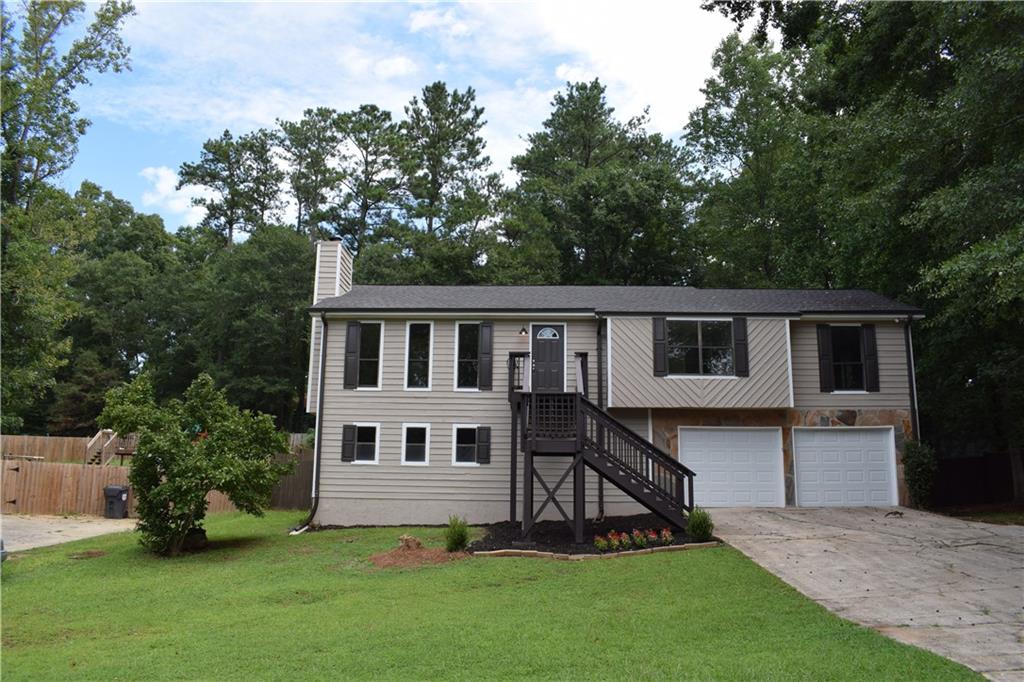 a view of a house with a yard and sitting area