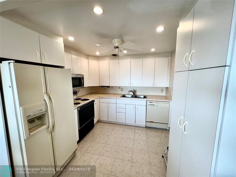 a kitchen with a refrigerator a sink and cabinets