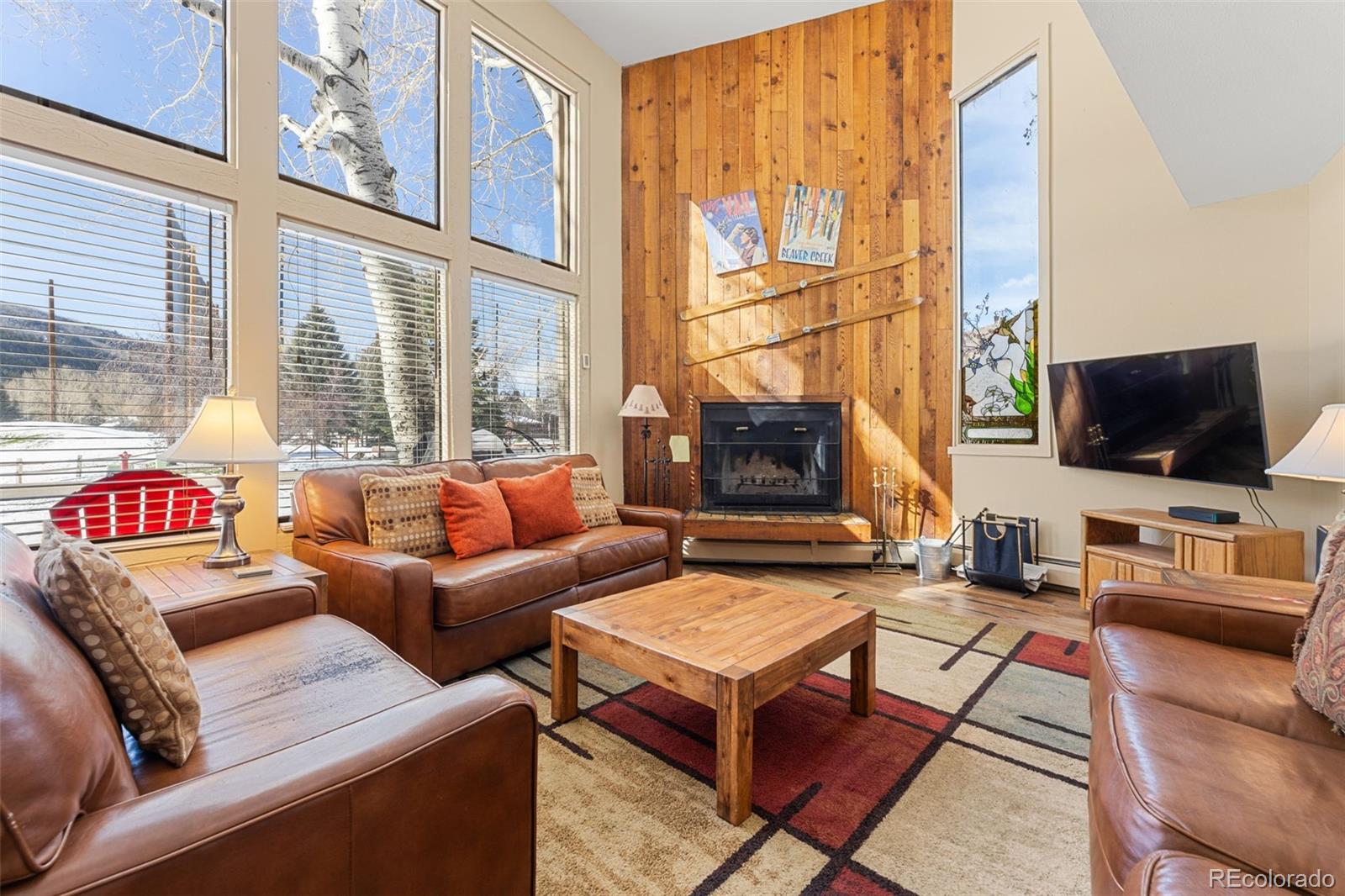 a living room with furniture a flat screen tv and a fireplace