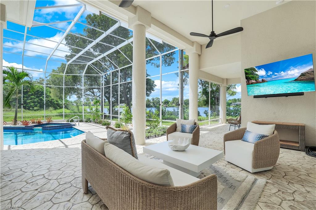 a living room with patio furniture and a floor to ceiling window